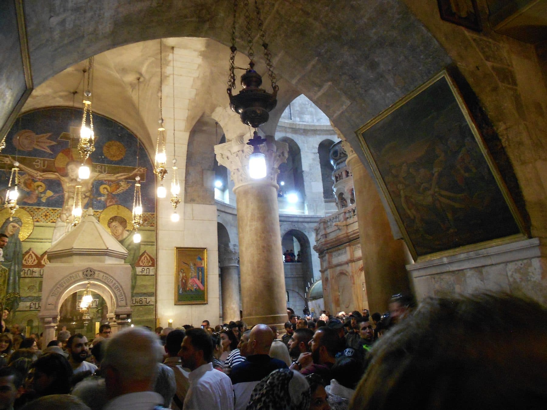 Worshippers gathered inside the lamp-lit Church of the Holy Sepulchre, Jerusalem, before the Aedicule during the Holy Saturday Holy Fire ceremony.