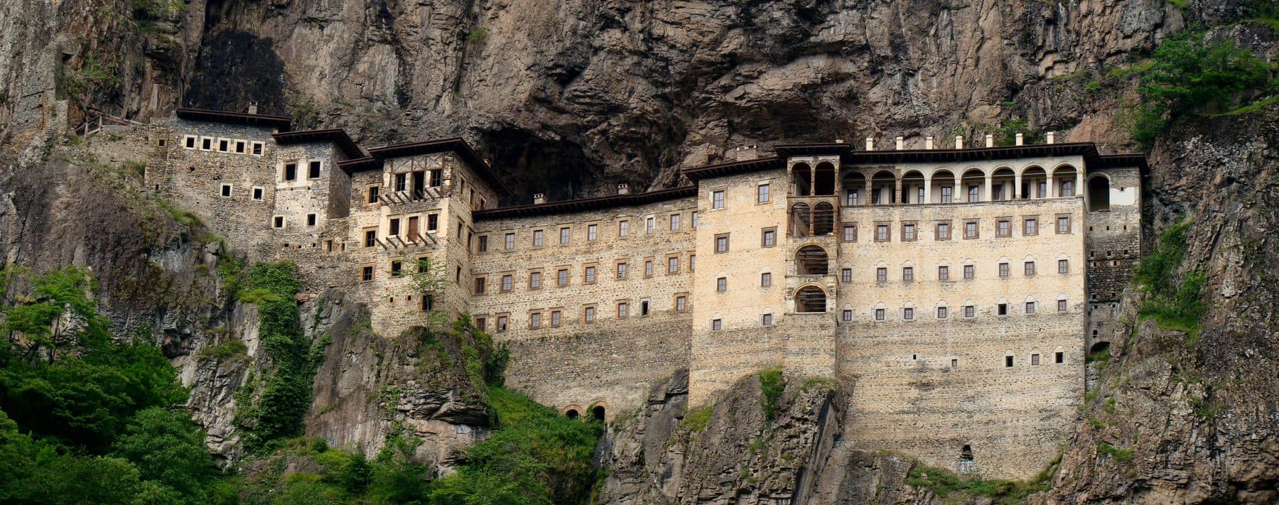 The stone Sumela Monastery built into a sheer forested cliff face high above the Altındere valley near Trabzon, Turkey — home of the Panagia Soumela icon.