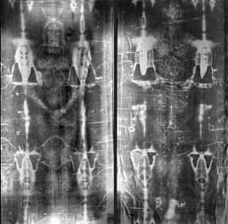 Full-length front-and-back photographic negative of the Shroud of Turin, showing the faint image of a crucified man — the form in which the body and face are most clearly visible.