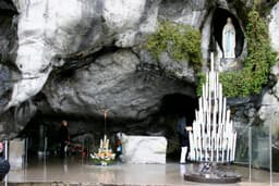 The Grotto of Massabielle at Lourdes, France — the limestone cave with the statue of Our Lady in a niche above the spring, site of the Lourdes pilgrimage.