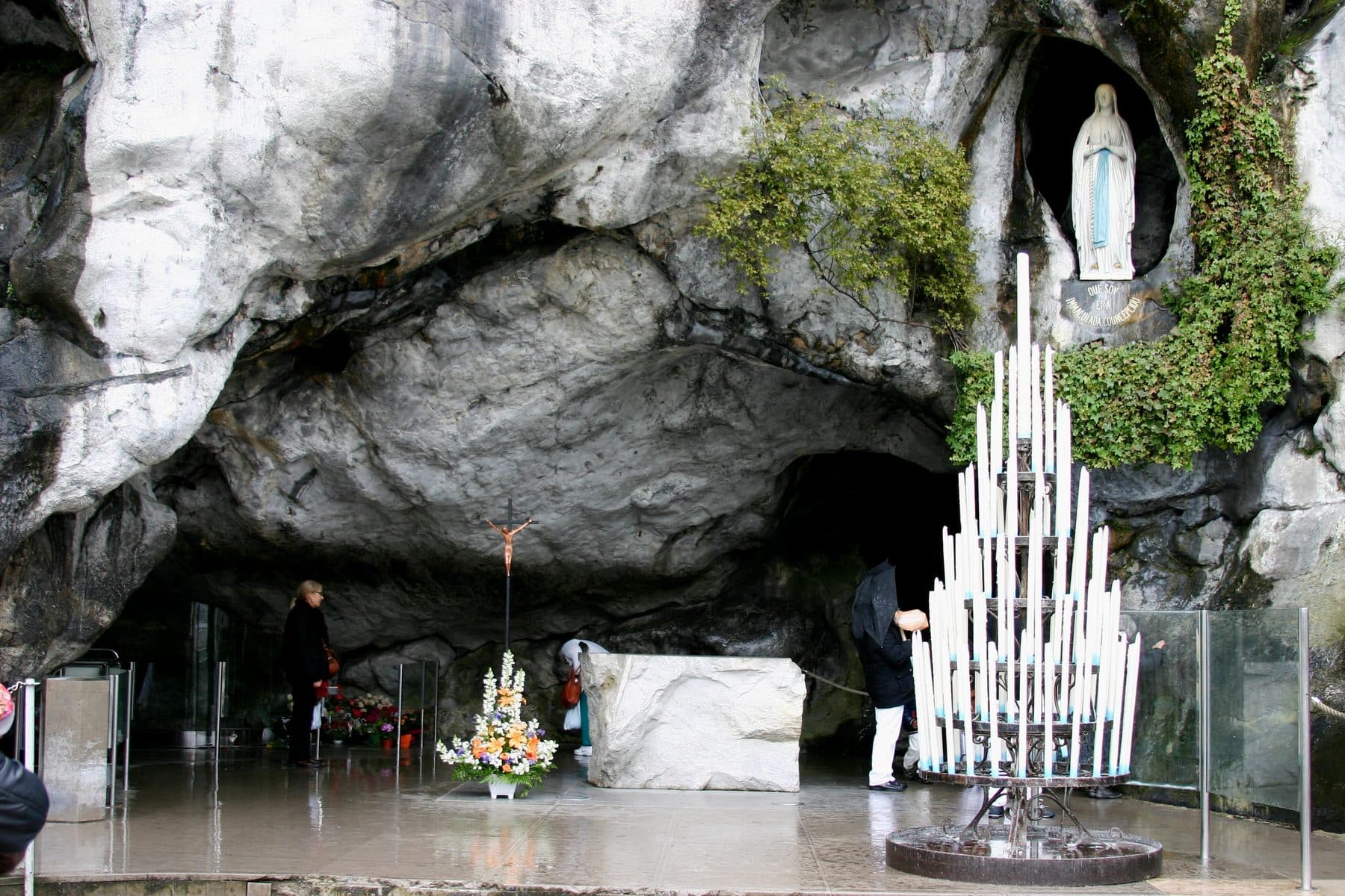 The Grotto of Massabielle at Lourdes, France — the limestone cave with the statue of Our Lady in a niche above the spring, site of the Lourdes pilgrimage.