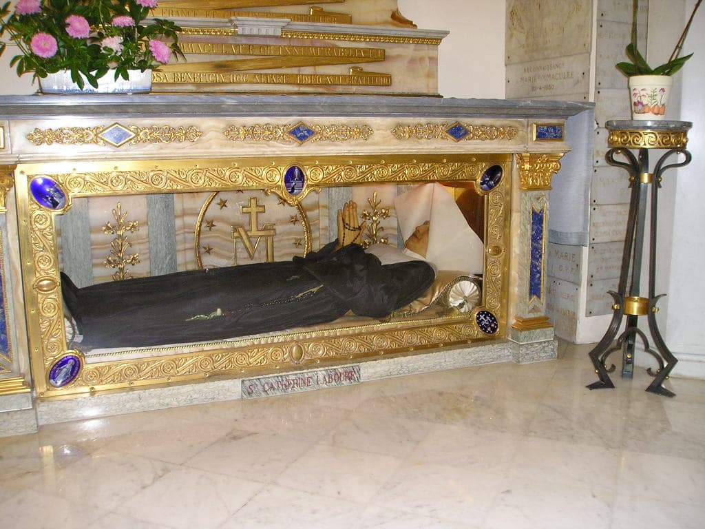 The incorrupt body of St Catherine Labouré, in the habit of the Daughters of Charity, lying in a glass reliquary beneath an altar in the Chapel of the Miraculous Medal, rue du Bac, Paris.
