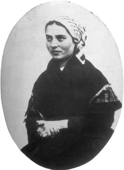 An 1863 studio portrait of St Bernadette Soubirous, the visionary of Lourdes, seated in plain peasant clothing with a headscarf.