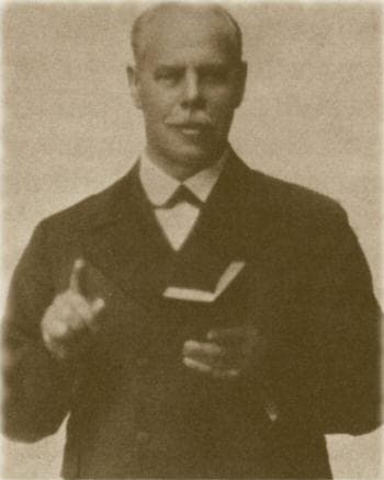 Black-and-white photograph of evangelist Smith Wigglesworth preaching with his Bible, circa 1920